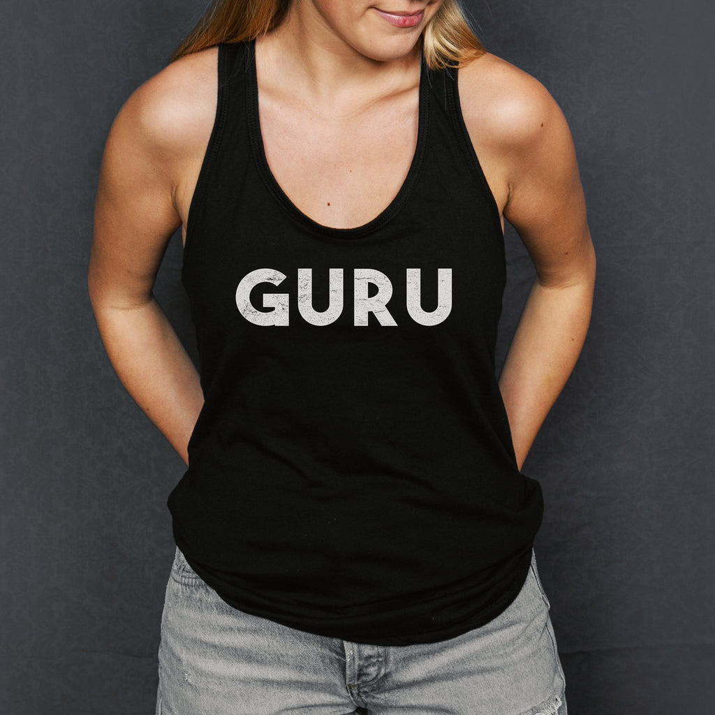 Woman in black tank top that says the word 'GURU' on the front in white distressed lettering