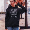 Woman wearing Black hoodie sweatshirt with reverse white letters that say See The World Differently backwards