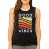 Woman wearing heather black good vibes muscle tank with retro red, orange and yellow distressed rainbow