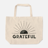 Natural canvas weekender tote bag with faded black sun above the word "GRATEFUL"