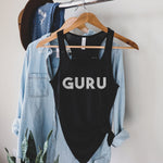  Womens black racerback tank top that says the word 'GURU' on the front in white distressed lettering