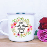 Silver rimmed white camp mug with flowers and the message " I like pretty things and the word fuck"