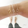 3 knot bracelets on womans wrist: gold, silver and rose gold