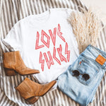 Womens white tee shirt that says 'LOVE SUCKS' in distressed pink rocker font