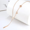 Rose Gold lariat necklace with lowercase letters spelling "love" with the letter "l" hanging down the center