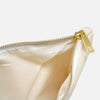 Gold zipper on white canvas cosmetic bag