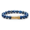 Blue lapis beaded bracelet with gold tube clasp that holds a paper message inside