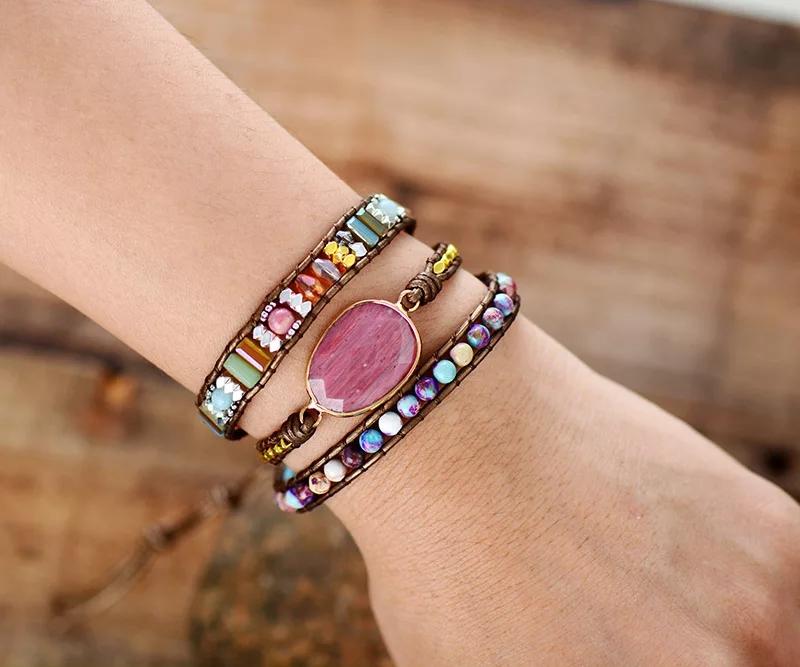 Leather boho wrap bracelet with large pink rhodonite gemstone centerpiece and pink, purple, and metallic beads