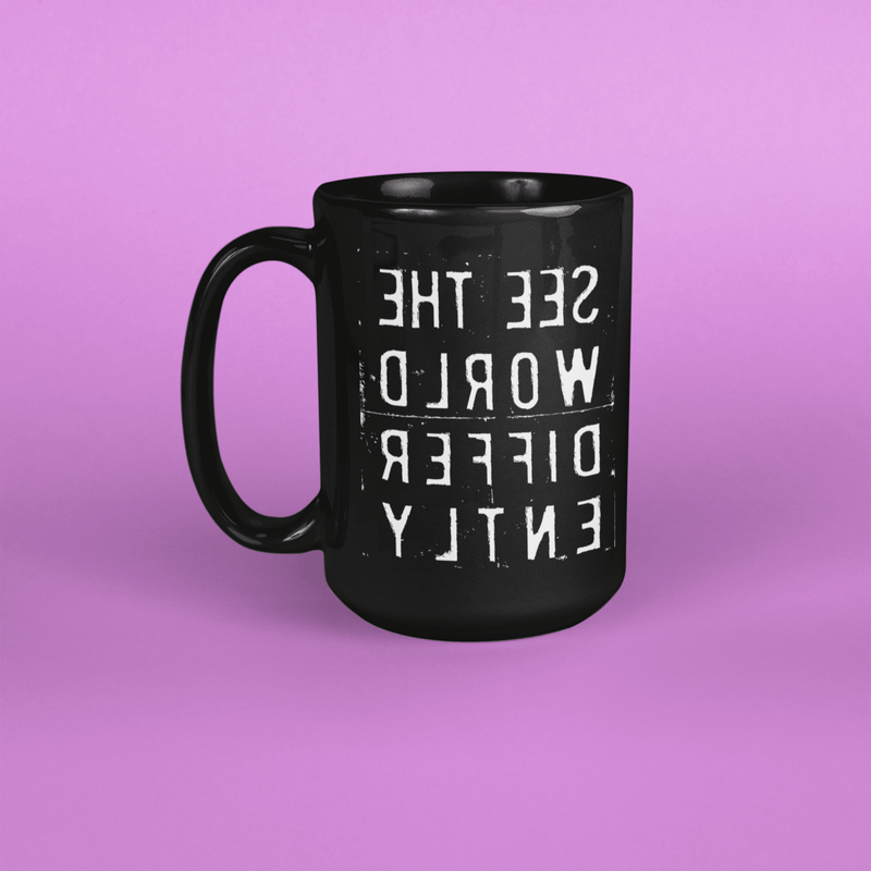 Tall black coffee mug with the message 'SEE THE WORLD DIFFERENTLY' backwards