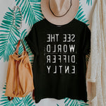 Summer Black T-shirt with reverse white letters that say See The World Differently backwards 