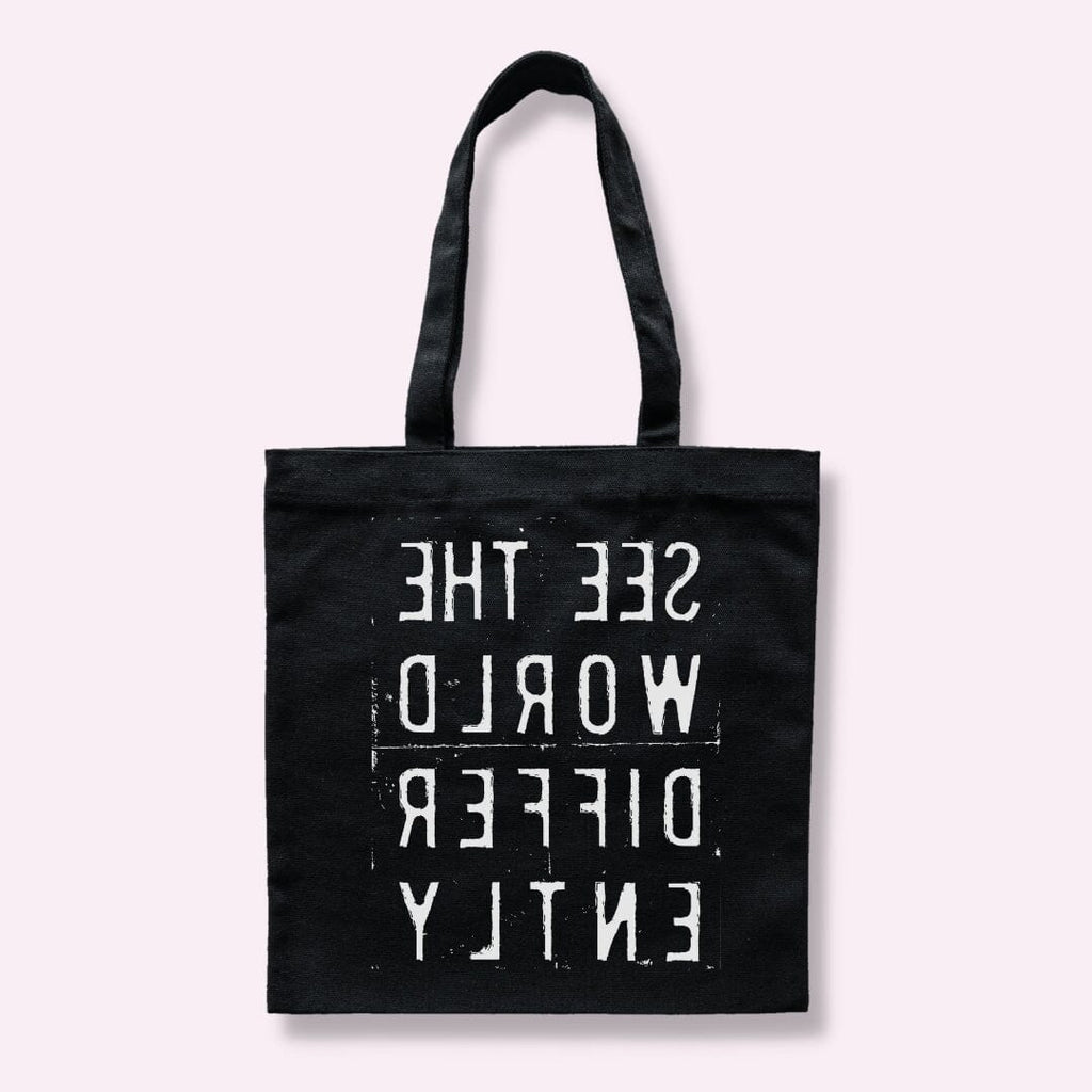 Black tote bag with backward letters that say "SEE THE WORLD DIFFERENTLY "
