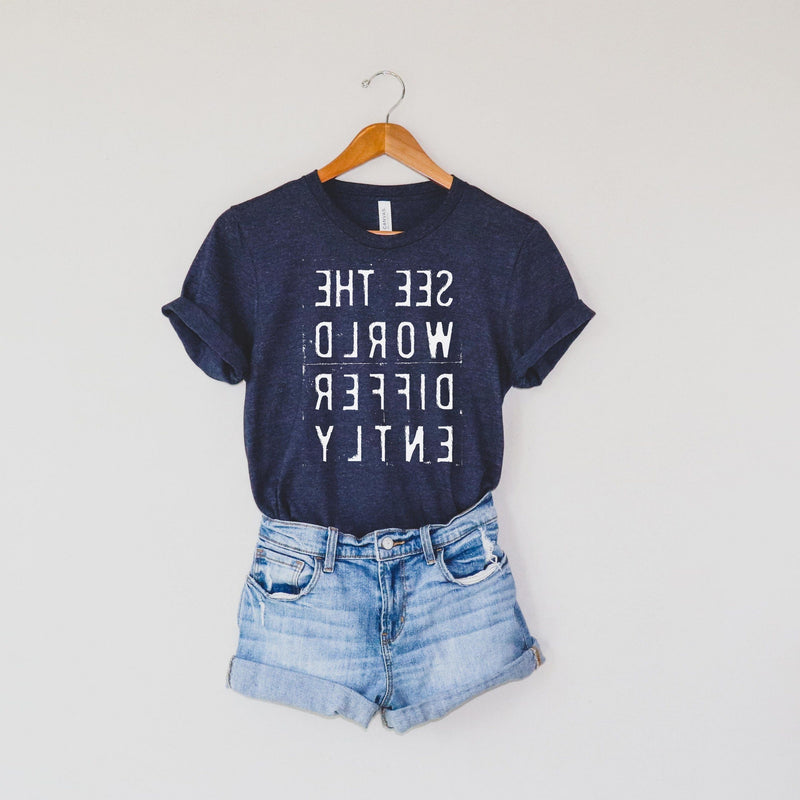 Heather Navy Blue T-shirt with reverse white letters that say See The World Differently backwards