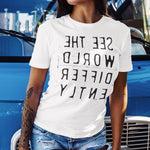 Woman wearing White T-shirt with reverse black letters that say See The World Differently backwards