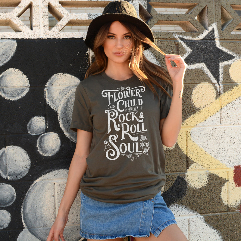 Woman wearinf army green T-shirt with distressed white Flower Child With A Rock and Roll Soul graphic